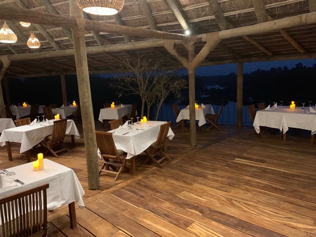 Restaurant de Niokolodge, tables dressées sous la charpente en bois