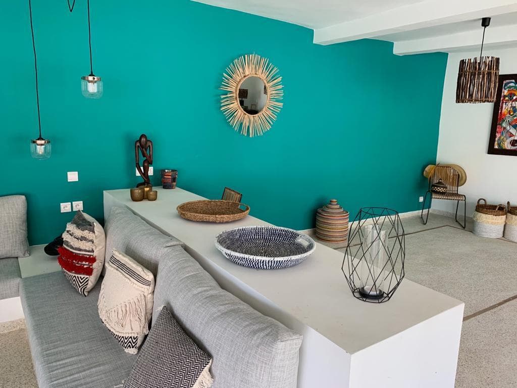 Salon intérieur de la villa : mur turquoise et banquette maçonnée